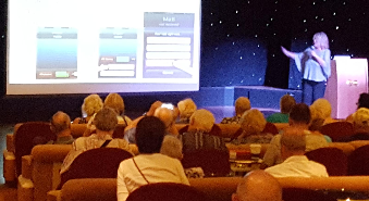 Dane McKeever presenting to an audience on a cruise ship